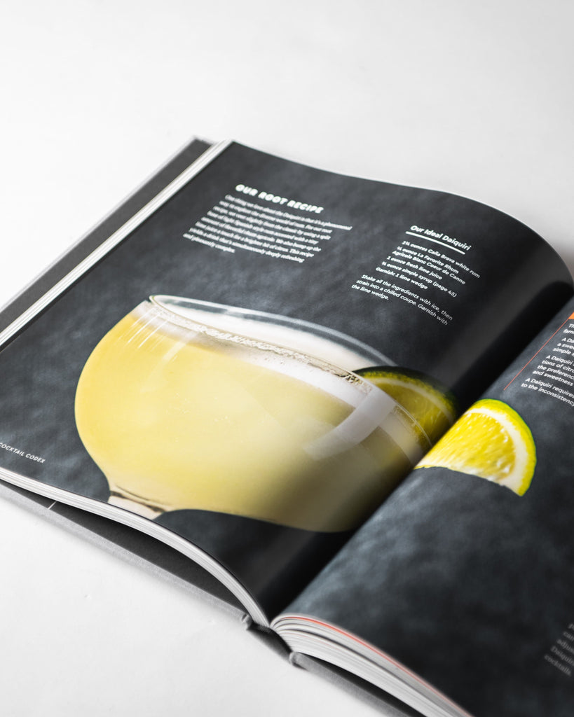 "cocktail codex: fundamentals, formulas, evolutions" book opened to page with yellow drink