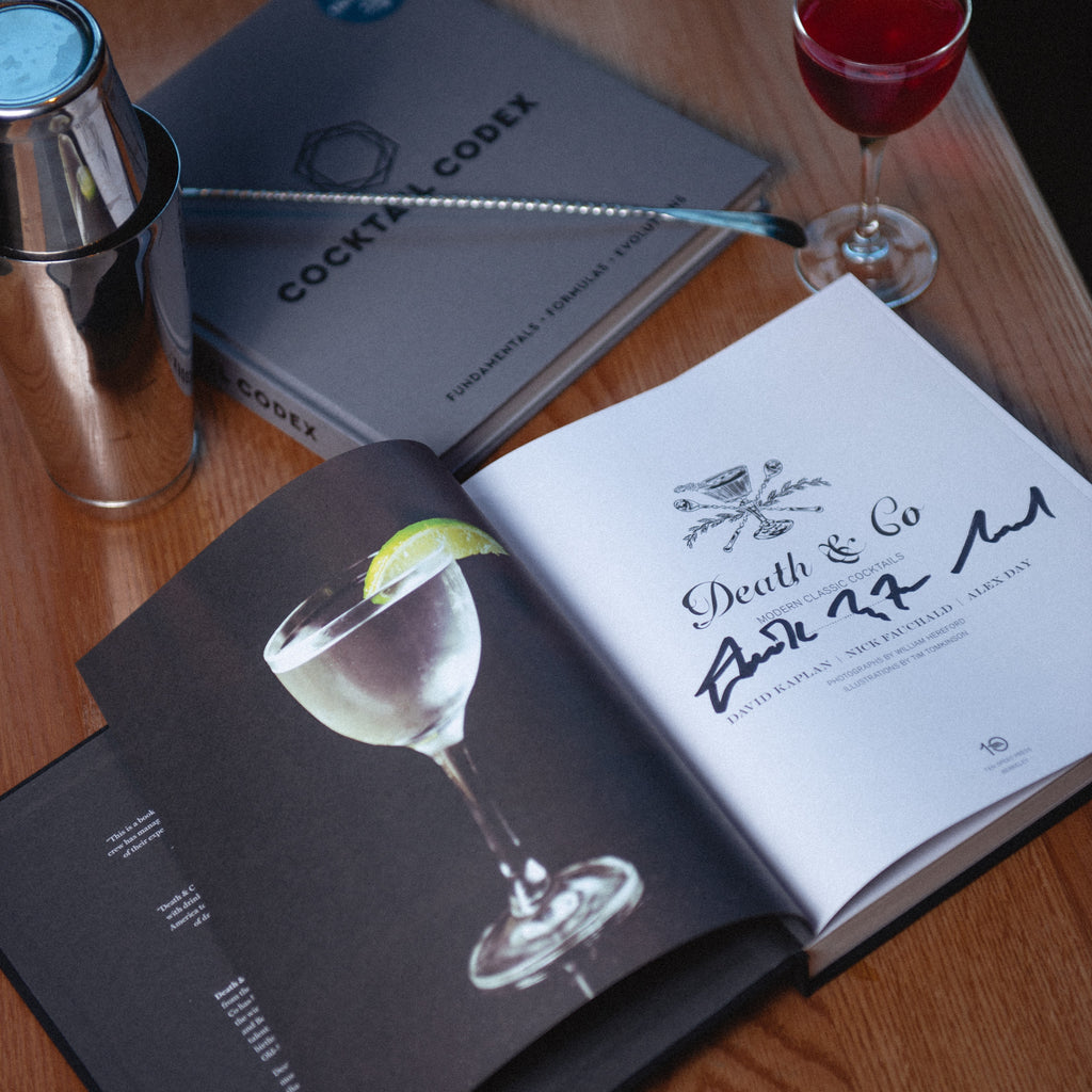 Death & Co. Modern Classic Cocktails book opened with signatures from authors 