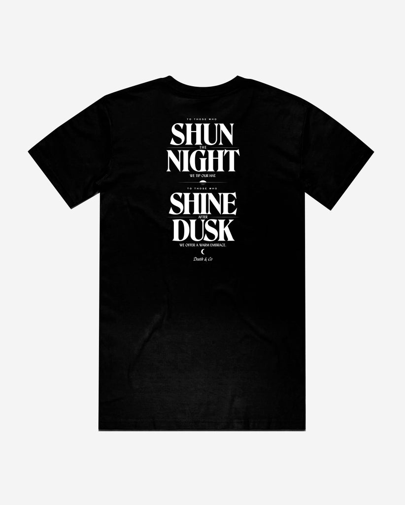 back of black tee with "to those who shun the night we tip our hat. To those who shine after dusk we offer a warm embrace"