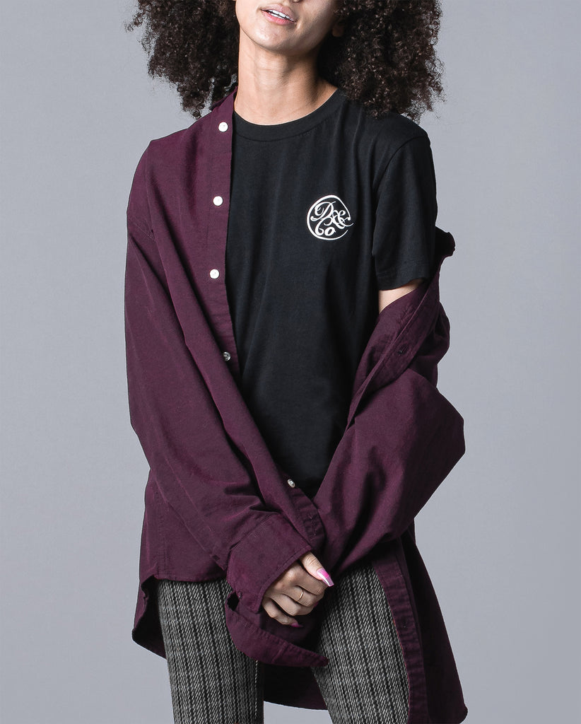 front of woman wearing black tee with death & co. logo on pocket