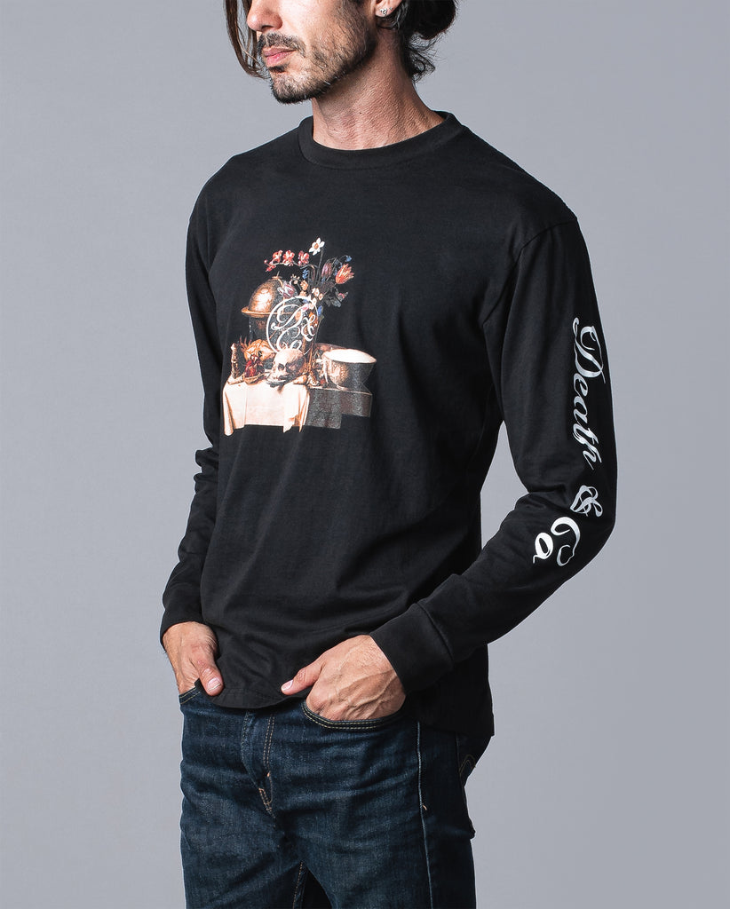 man wearing black long sleeve with table of food and drinks graphic and death & co. logo