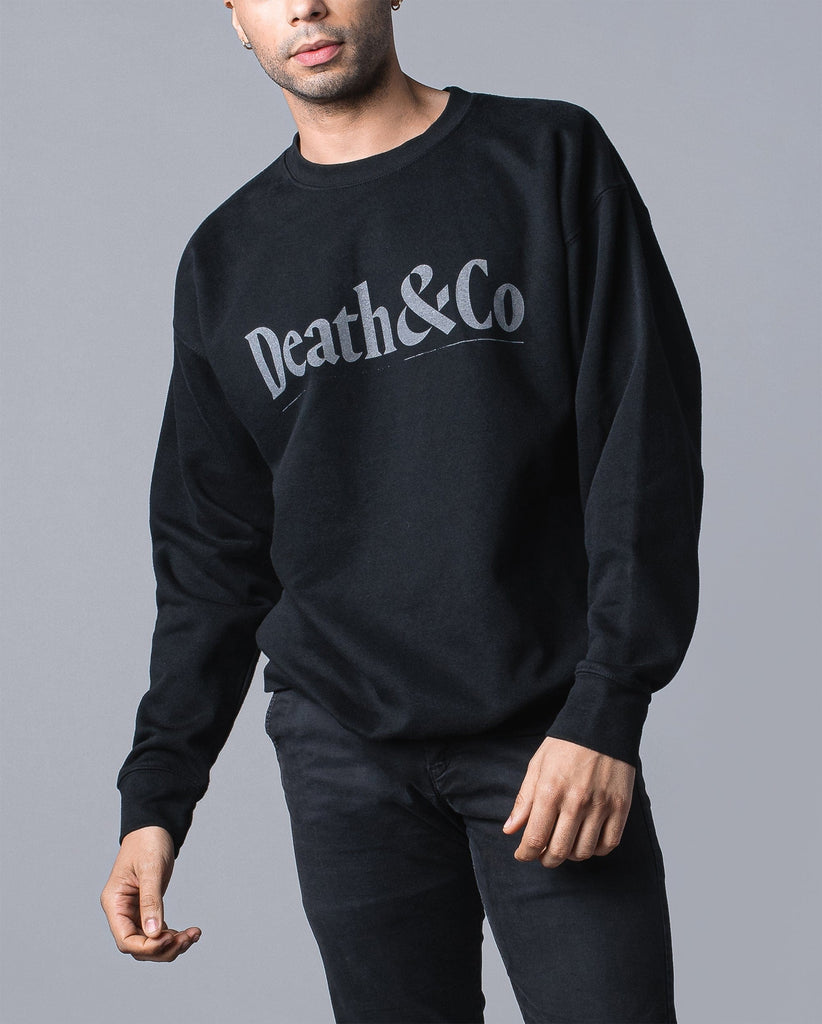 man wearing black crew fleece with "death & co" across chest