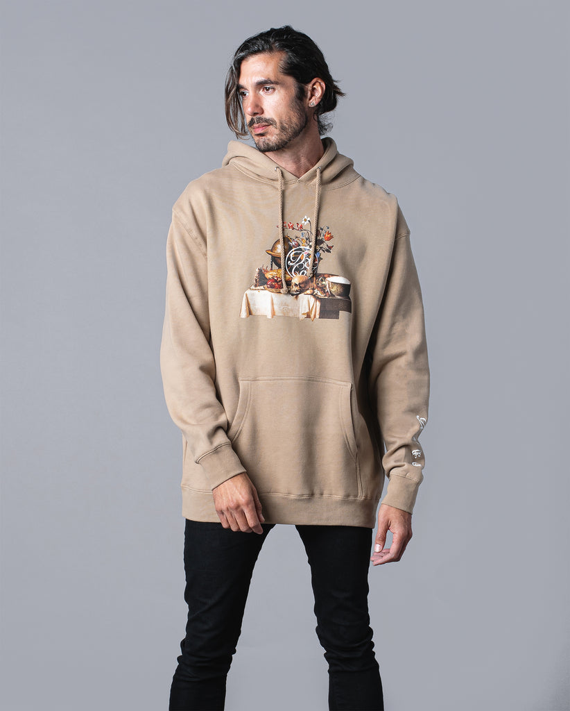 man wearing tan hoodie with table of food and drinks graphic and death & co. logo