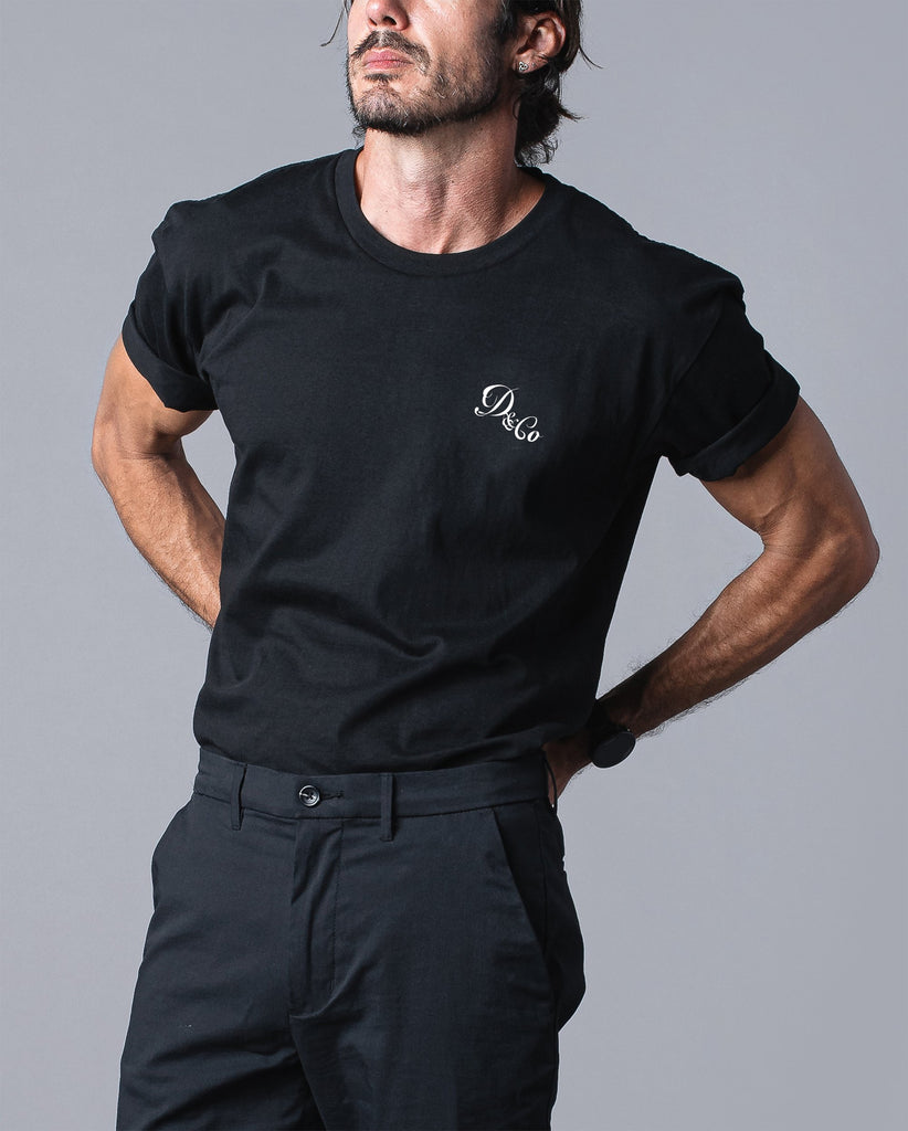 front of man wearing black t-shirt with death & co. logo on pocket