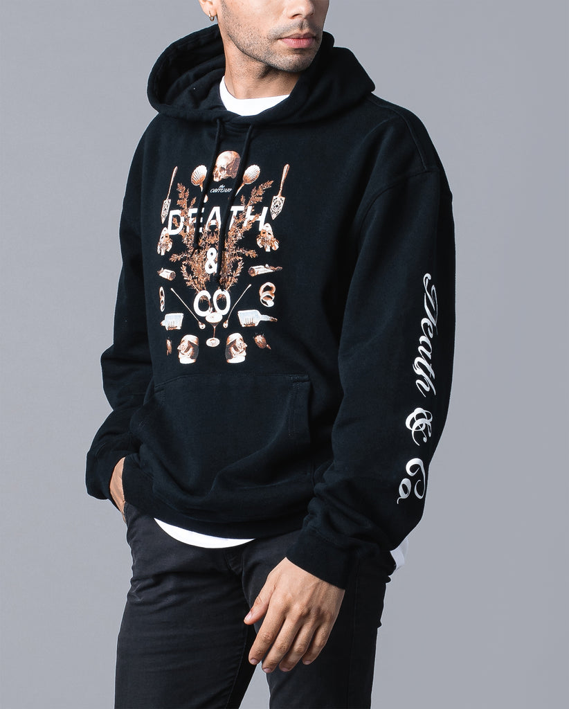 man wearing black obituary hoodie with "death & co. on sleeve"